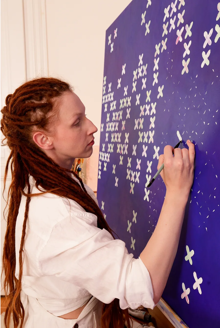 Alicja Suska painting an X-shape pattern